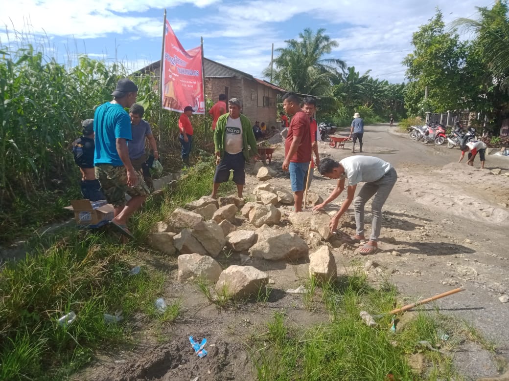 KOLABORASI PERANGKAT DESA DAN JEMAAT HKI NAGOJOR UNTUK MEMPERBAIKI JALAN
